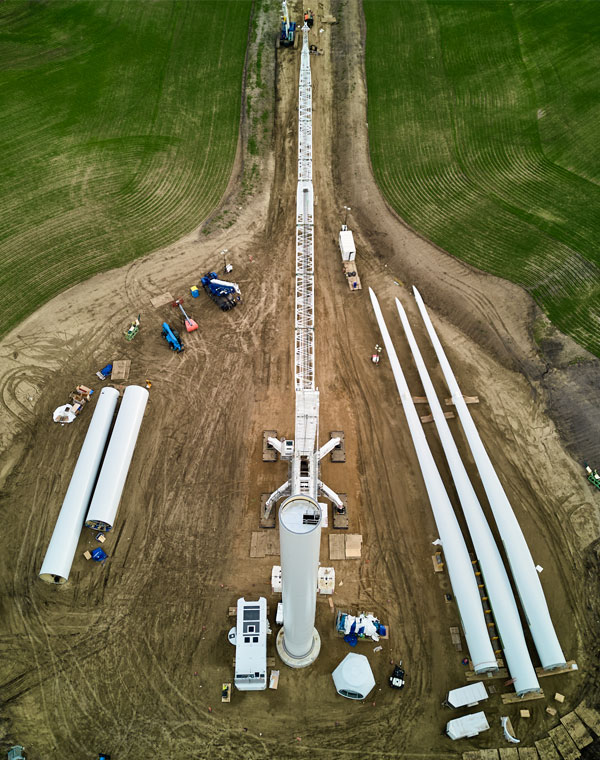 Aerial view of a wind turbine being assembled on farmland